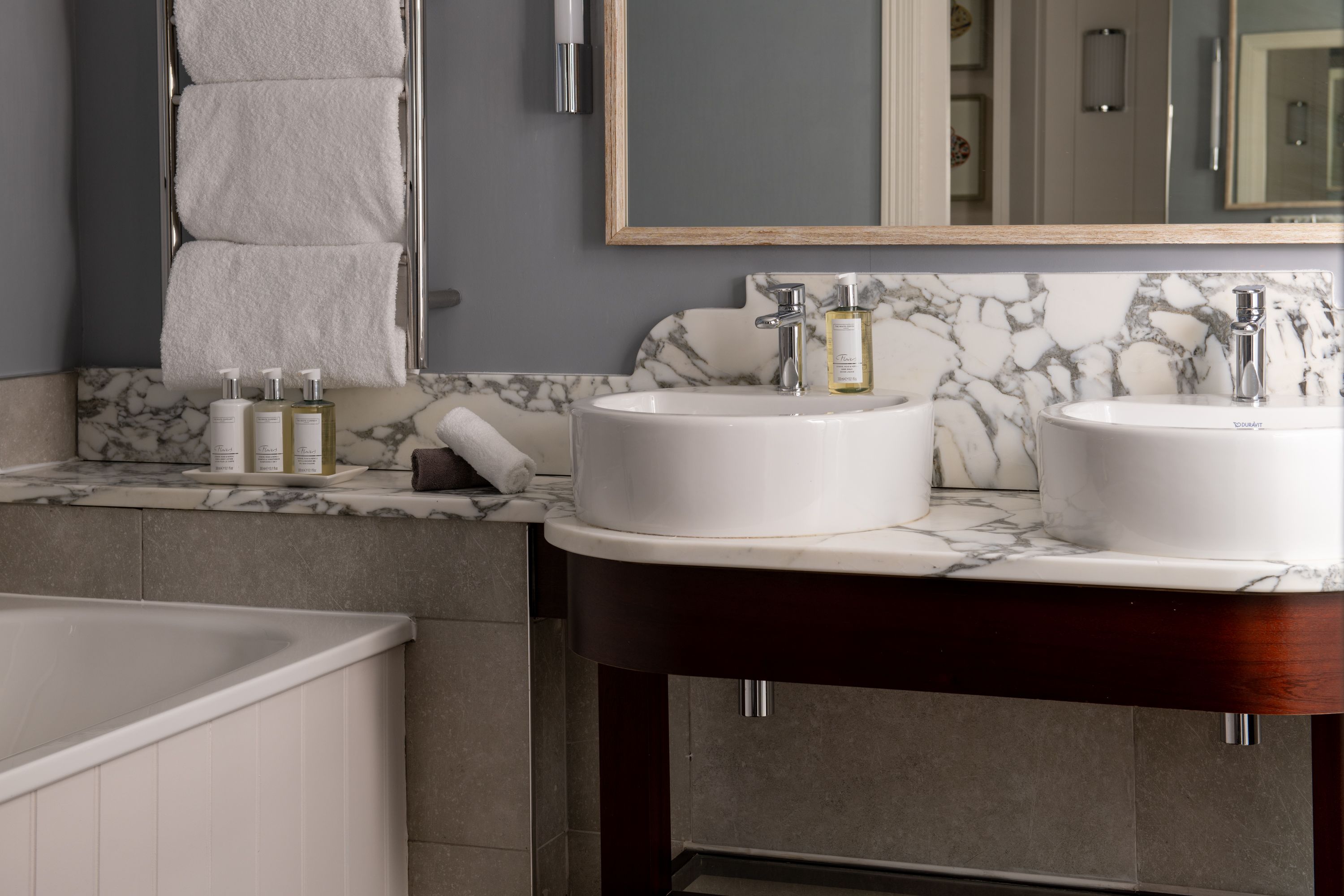 marble bathroom with two sinks and a bath