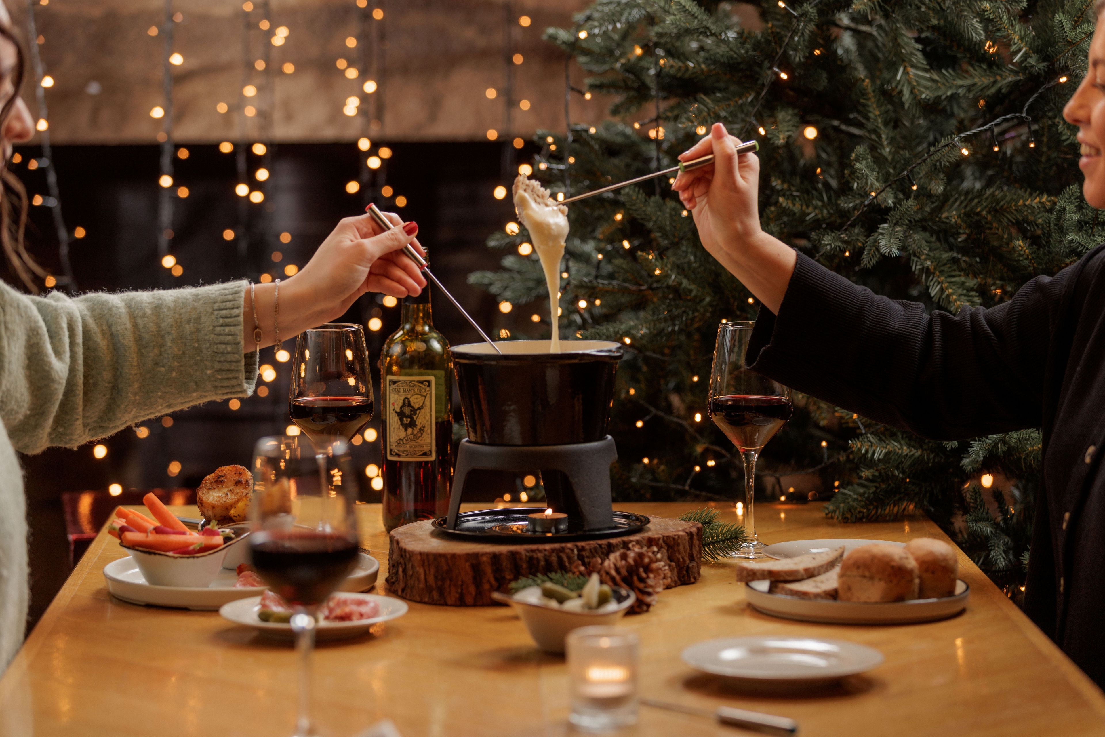 two people sharing cheese fondue with savoury treats